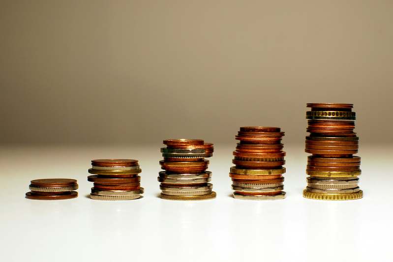 Diverse hands placing coins into a transparent piggy bank labeled 'WealthPath'